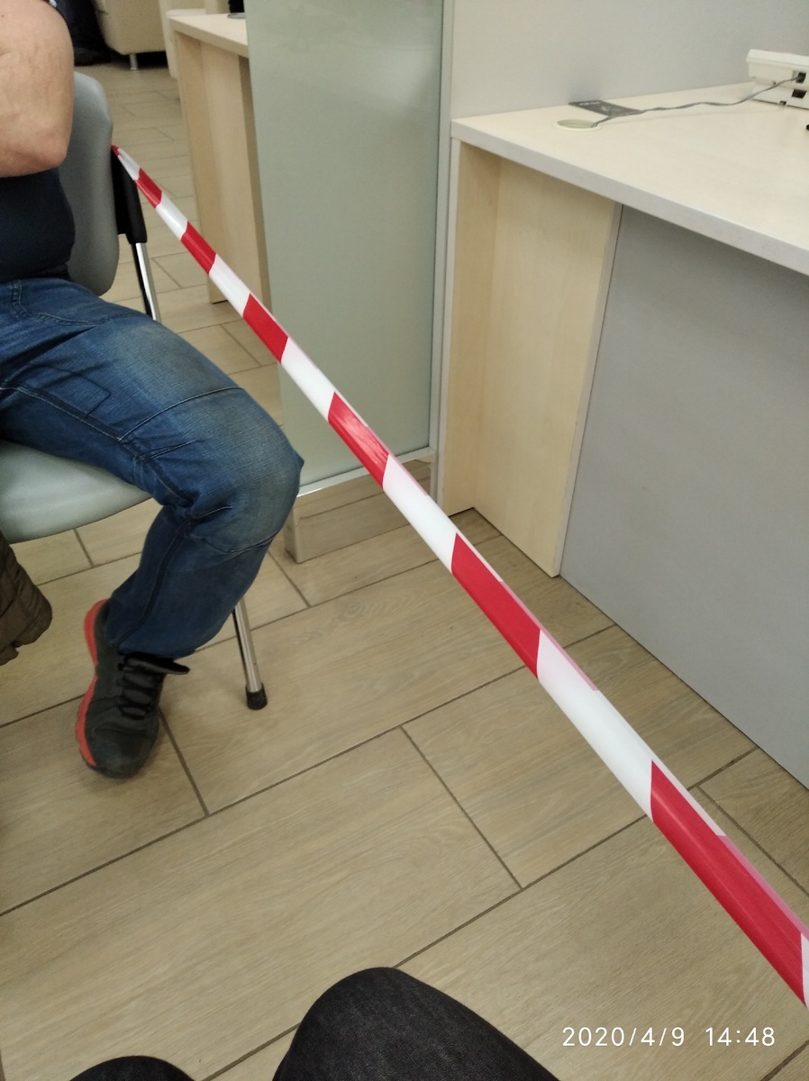 Внизу фото мои колени, вверху мужа. Справа стол работницы банка. Расстояния больше, чем смотрятся на фото, сидя на стуле, достать до стола нельзя.