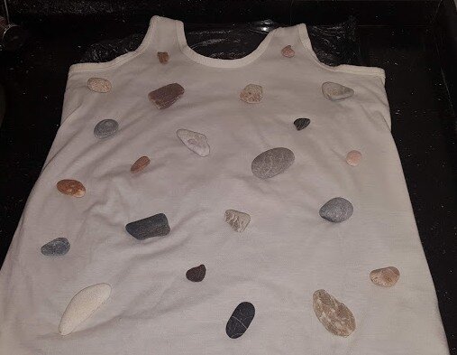 Морские камешки  разложены на майке.