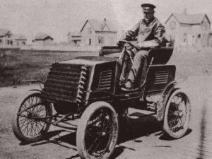 Сегодня, садясь в свой автомобиль, мало кто может представить его без главного органа управления – руля. С момента создания первого автомобиля конструкторы достаточно быстро пришли к его традиционной форме. Но и эта часть автомобиля со временем подвергалась различным модернизациям и имеет свою отдельную историю.Управление первыми самоходными экипажами осуществлялось посредством румпеля — специальной рукоятки, заменяющей руль
По мнению многих, автомобиль был изобретен одновременно с рулевым колесом, но это совсем не так. Руль изобрели значительно позже, ведь до наиболее удобной формы для прибора управления, нужно было дойти практическим путем. Как оказалось, овальный или круглый руль — это наиболее оптимальное средство для управления автомобилем.Первыми автомобилями управляли с помощью румпеля, однако, в 1894 году Альфред Вашерон принял участие в гонке Париж — Руан с моделью «Panhard 4hp», которая была оснащена рулевым колесом. Это, как полагают, одно из самых первых использований такого принципа управления.Проведенные в 1894 году испытания показали преимущества рулевого колеса перед румпелем. Уже к 1898 году все серийные автомобили «Panhard» были оборудованы рулевым колесом. Эту тенденцию подхватили и другие автопроизводители, тем самым сделав круглый руль эталонным. После того, как Артур Кребс установил руль под наклоном, автомобилем стало управлять еще удобнее.Первые автомобили конца 19 — начала 20 века, оснащенные рулевым колесом
В течение десятилетия рулевое колесо полностью вытеснило рукоятку.Рули тех лет имели обязательно четыре спицы. Лишь фирма «Рено» (Renault) упорно устанавливала на свои автомобили пятиспицевые рули. Переход на трехспицевые баранки потребовал много времени, и впервые они появились в Америке в конце 20-х.
