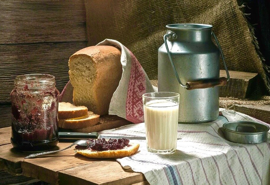 Завтрак со стаканом молока, бабушкиным вареньем и свежеиспеченным хлебом.