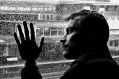 Мужчина грустит у окна