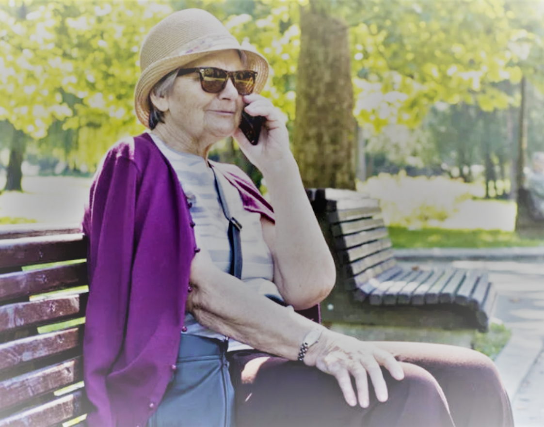 Светлана Юрьевна сидит на скамье в парке.