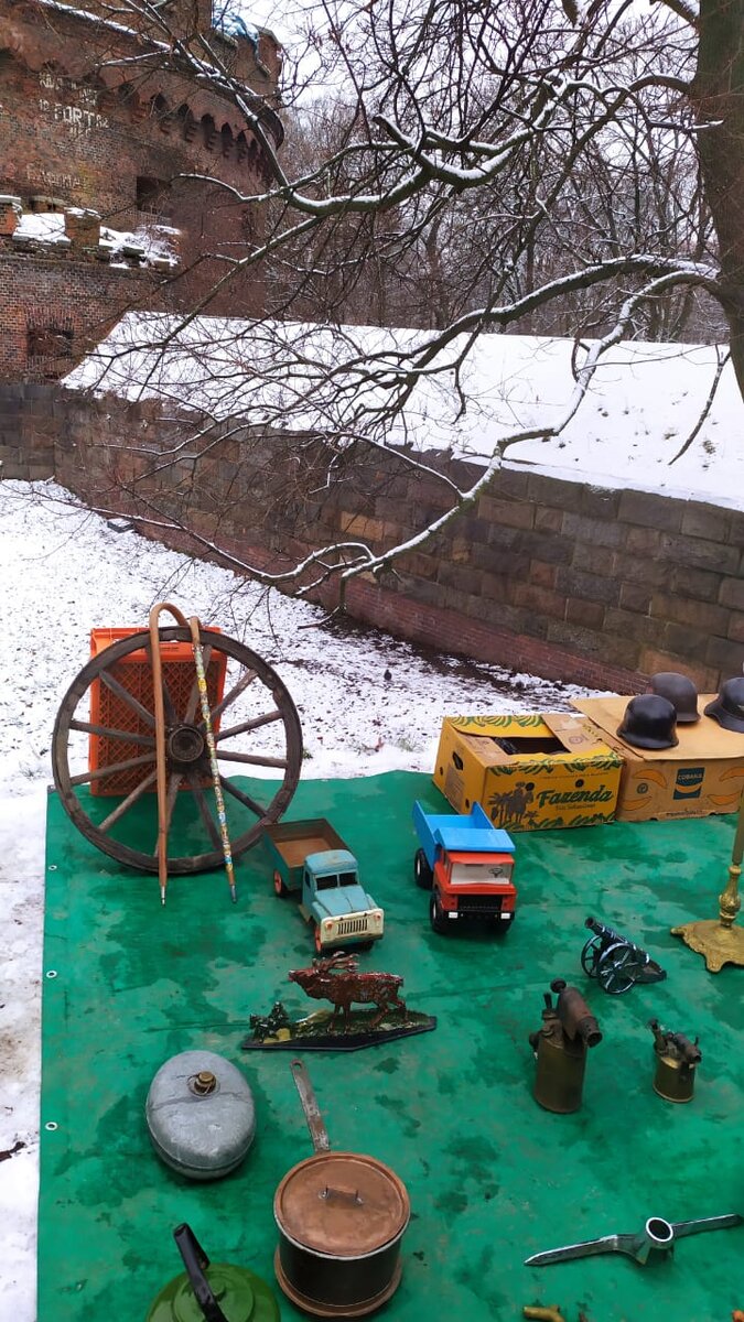 На ряду с машинками времен СССР лежат немецкие военный каски времен 40х годов 