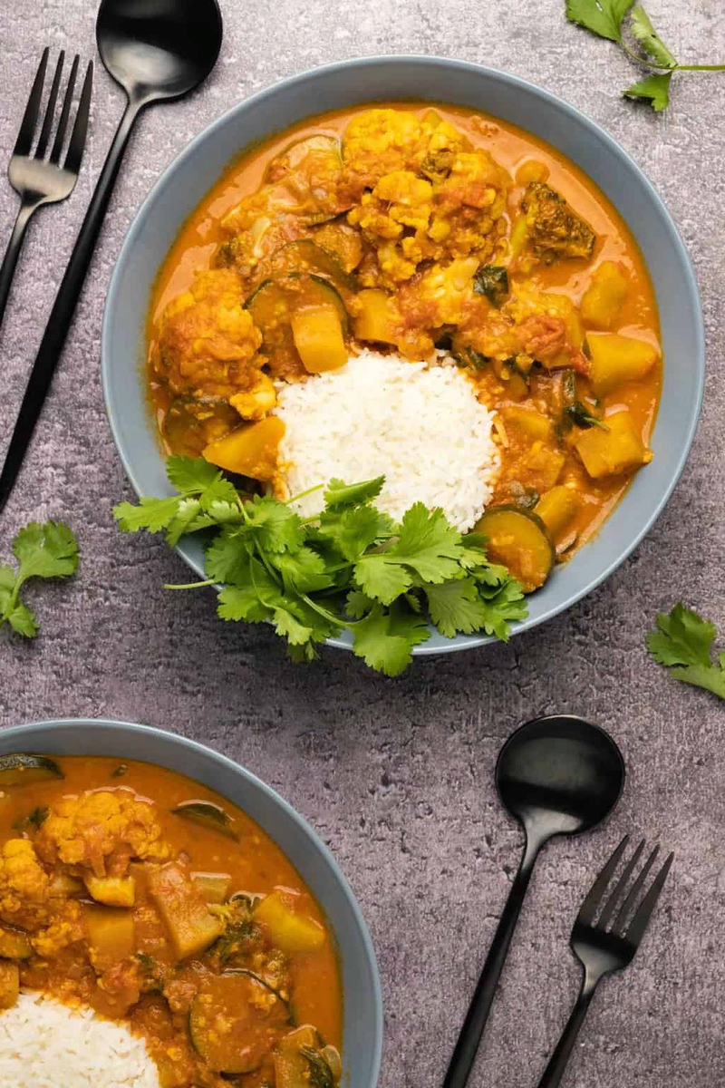 Вегетарианский карри из сладкого картофеля и овощей, тушеных в смеси кокосового молока и специй.