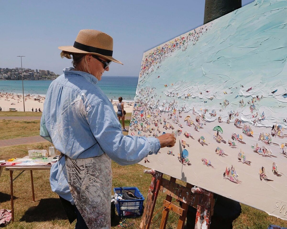 Салли Уэст за работой над картиной «День Австралии на Бонди Бич» 