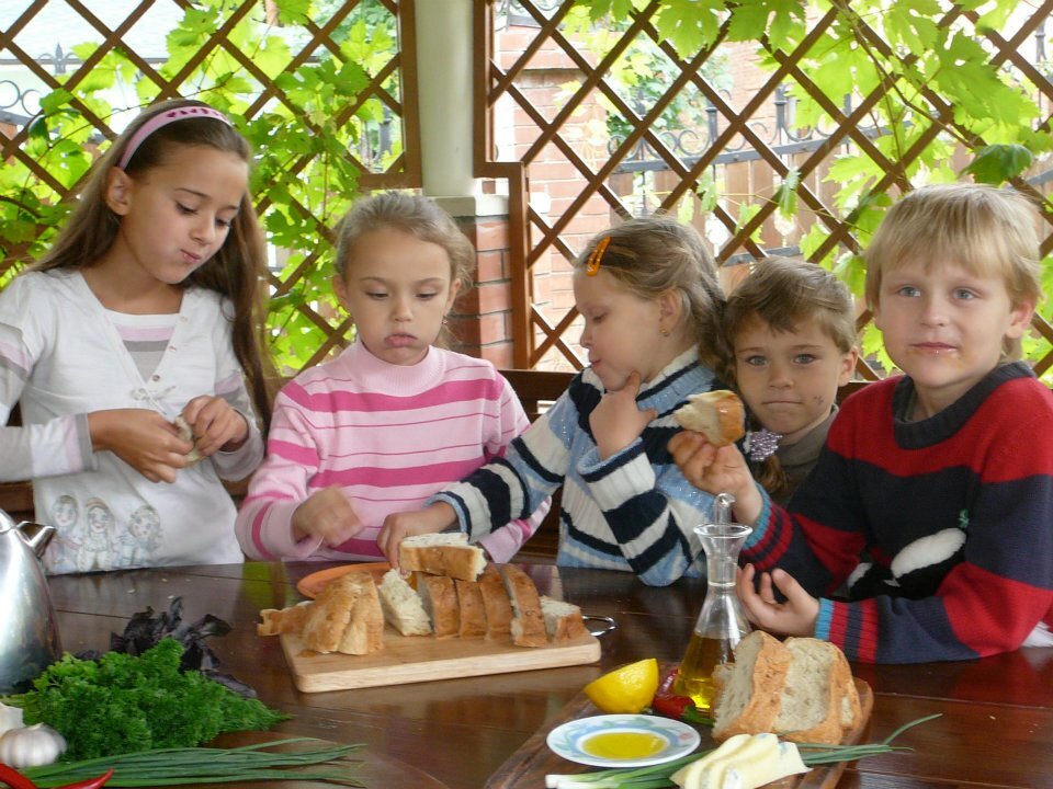 фото ООО Оливагифт - Дети едят хлеб без дрожжевой на закваске выпечен  Тимофеем Саламатовым и оливковое масло из Испании.