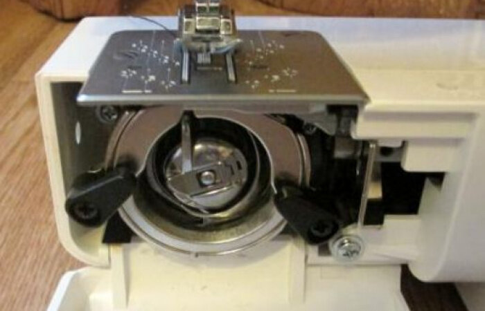 Как правильно установить челнок. Швейная машина Janome 1915. Челнок на швейная машинка Janome 2041s. Швейная машинка Janome 5519 узел челнока. Швейная машина Джаноме 3035 Шпульный механизм.