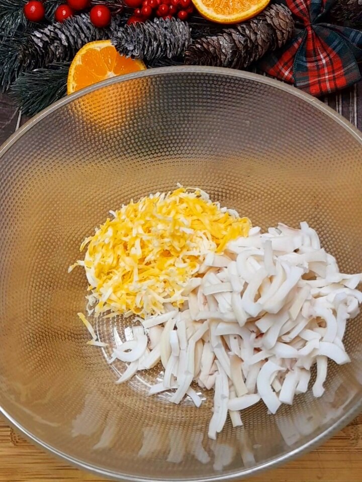 Кладем в ёмкость кальмар , к нему добавляем сыр твердый натертый на мелкой тёрке.