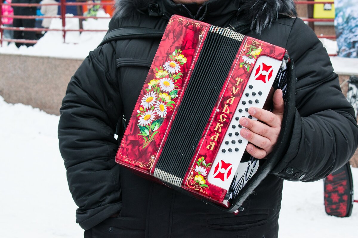 Мужчина с русской гармошкой в руках . Рубаха - парень