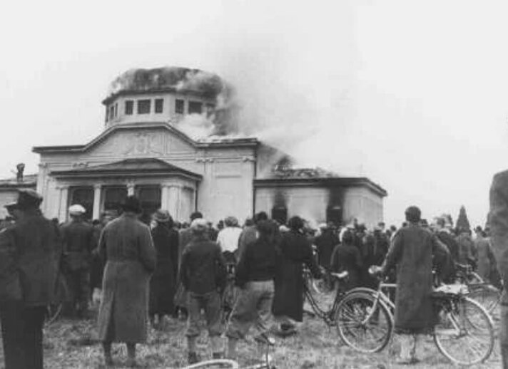 Местные жители смотрят, как горит церемониальный зал еврейского кладбища в Граце во время “Хрустальной ночи”. Грац, Австрия, 9-10 ноября 1938 года.