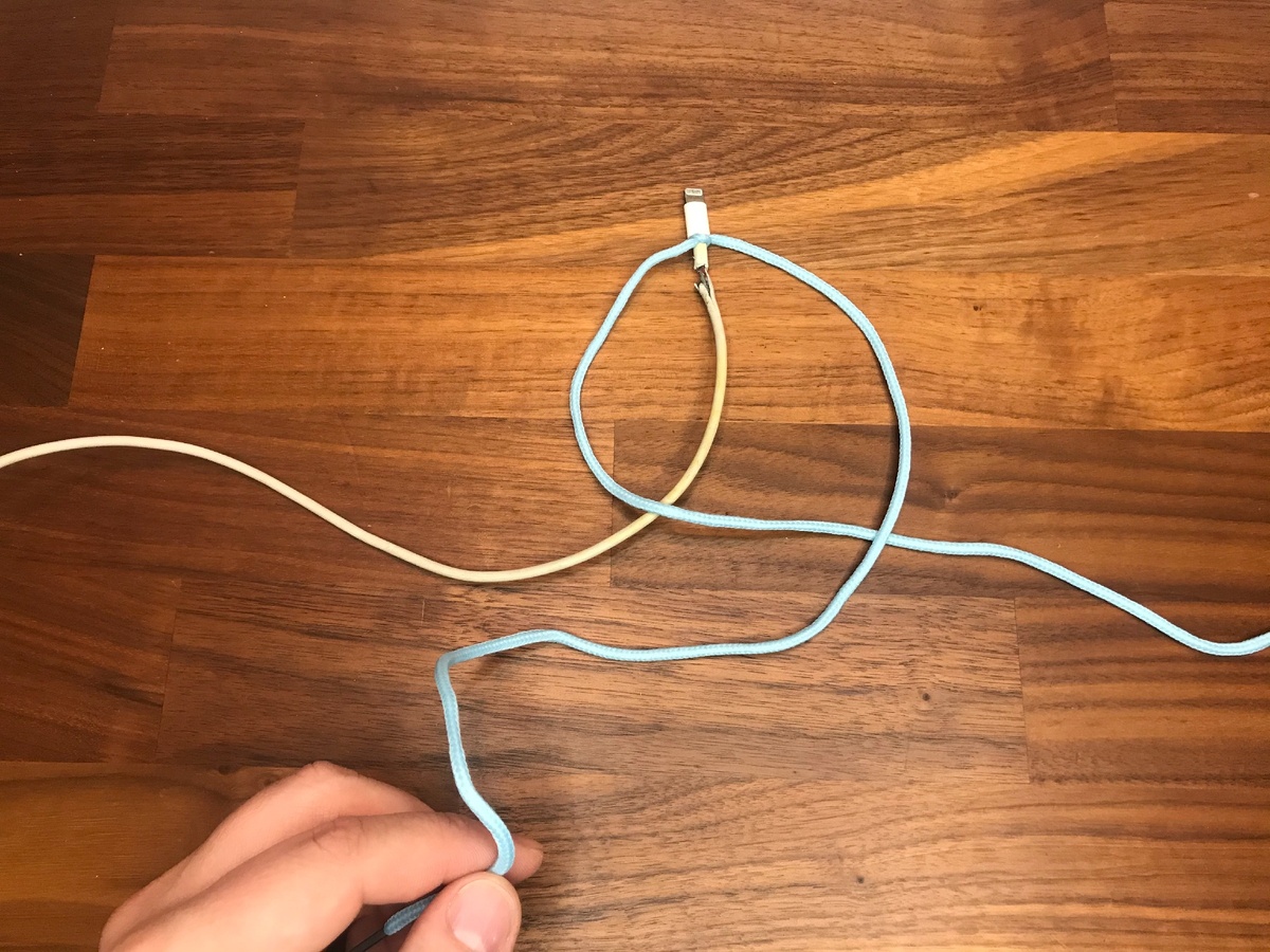 На второй петле верхний конец шнурка заводим под провод