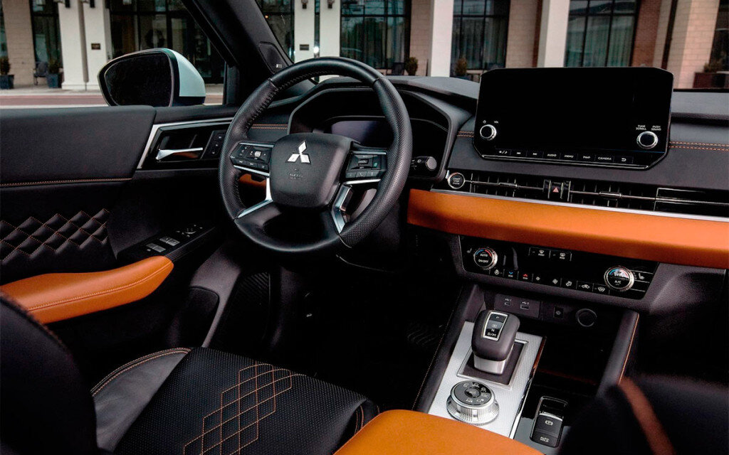 Передняя часть салона Mitsubishi Outlander четвертой генерации с комбинированной обшивкой сидений. 
