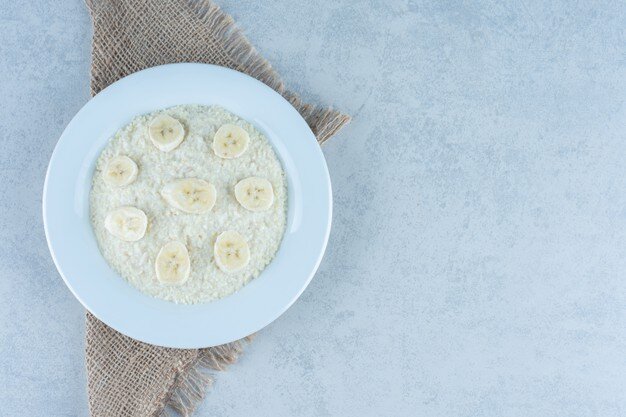 Freepik.com Нарезанный банан на тарелке с рисом 