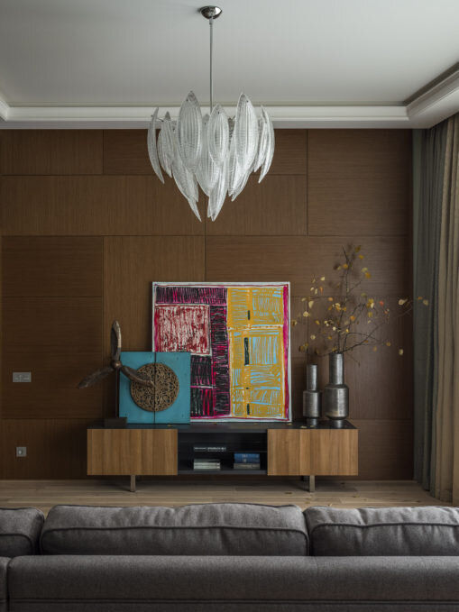 Чтобы выделить зону гостиной, декораторы облицевали одну из стен деревянными панелями. Их сделала компания Leto. Тумба под телевизор, Mr.Doors.