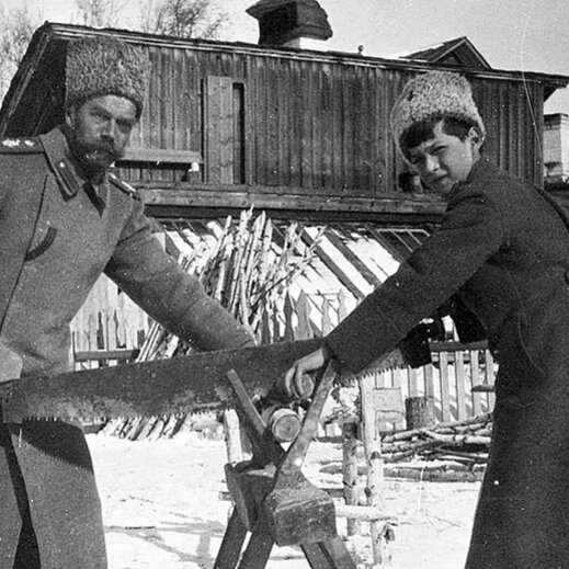 Это Николай с сыном Алексеем  пилят дрова. Фотография, доказывающая, что к своему 14 летию наследник вылечился от гемофилии.