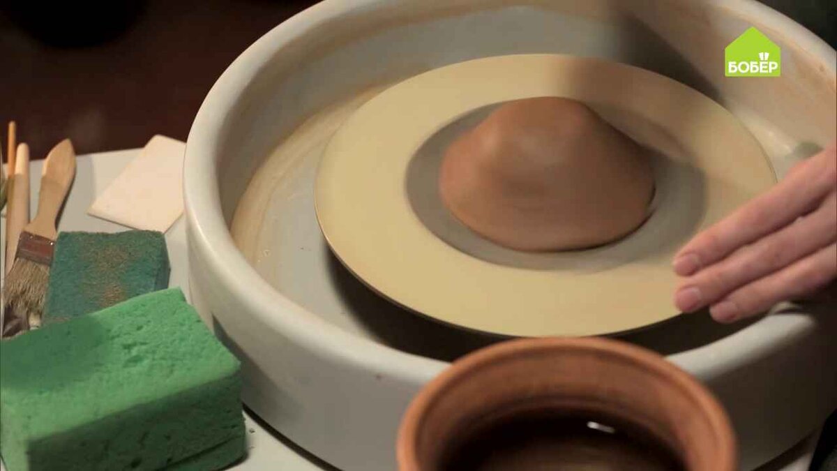 Примните кусок глины, чтобы он не отвалился во время вращения, и включите гончарный круг.