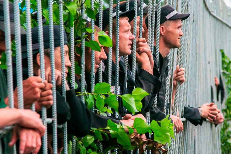 Осужденные на прогулке. Осужденные к лишению свободы. Зек за решеткой. Исправление осужденных. Амнистия лишенных