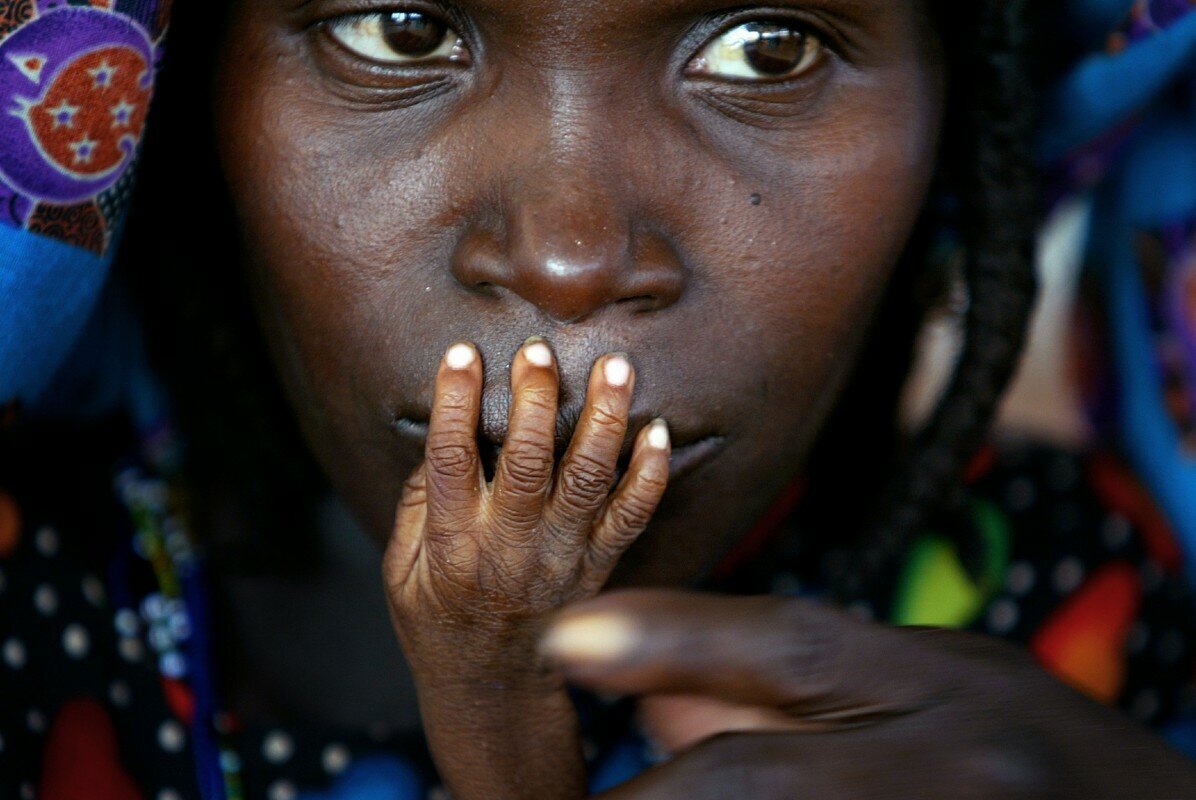 Tahoua, Niger. The fingers of malnourished 1-year-old Alassa Galisou press against the lips of his mother, Fatou Ousseini, at an emergency feeding center,  Finbarr O'Reilly