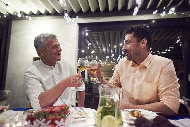 https://focusedcollection.com/ru/202764672/stock-photo-two-men-sitting-dinner-table.html