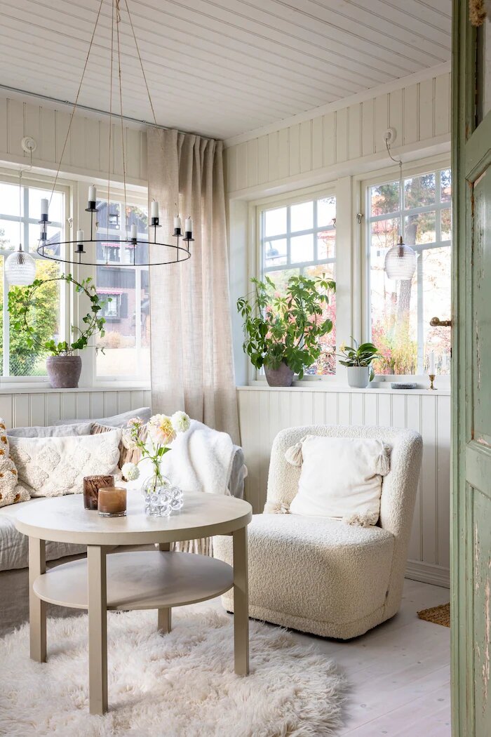 К дому пристроена современная застеклённая веранда с решетчатыми окнами и жемчужными стропилами.