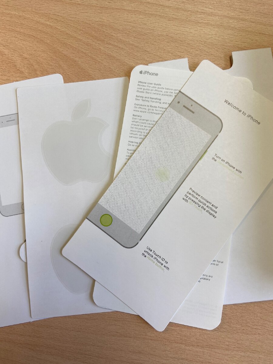 Внутренности упаковки. Скрепка, наклейка с яблоком и макулатура. 