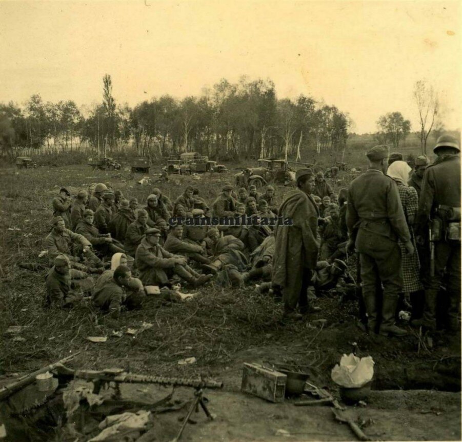 А фото действительно интересное. По всей видимости, немцы только что собрали на краю поля тех кто разбежался из попавшей в окружение автоколонны. И пленные и немцы на расслабоне, тем не менее штык примкнут. Справа женщина в гражданском и что-то похожее на отрытый окоп. Странно что земля на переднем плане сильно утоптана. Колонна выскочила на заранее подготовленную позицию?