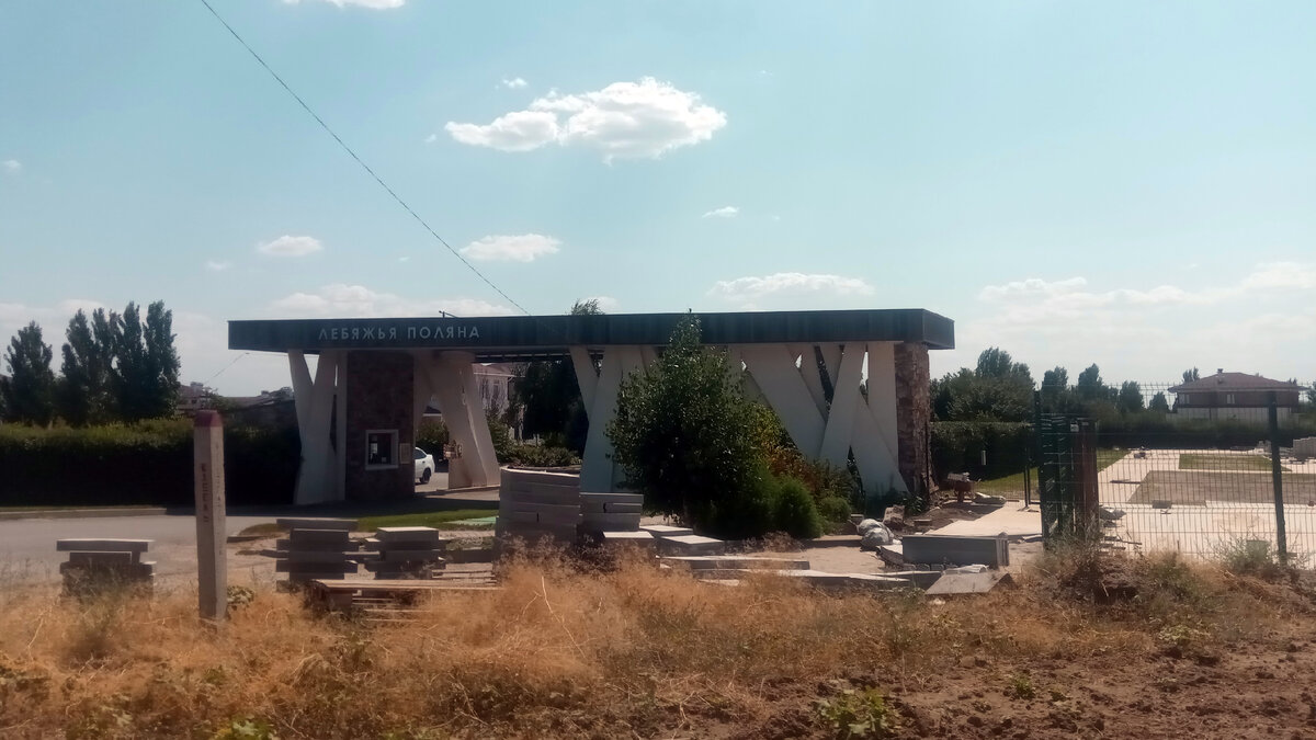 Возле въезда нагромождение стройматериалов. Посёлок хоть и заселён, но ещё строится