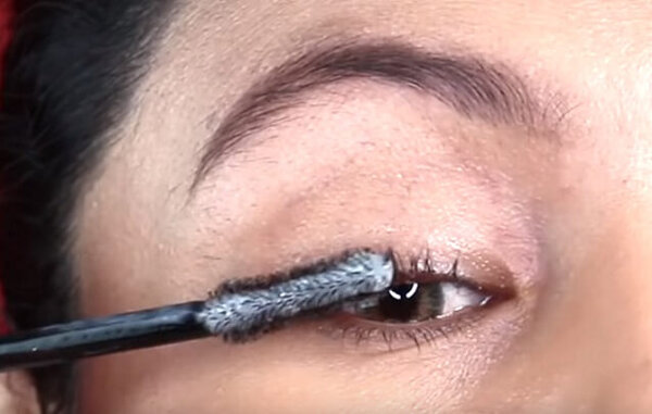 Процесс нанесения средства на ресницы с помощью щеточки