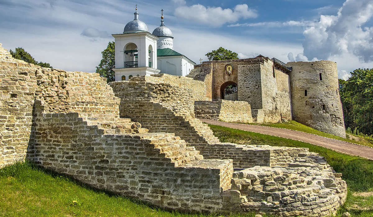 Изборская крепость. На переднем плане остатки Плоской башни, примыкающей к стене Никольского захаба, а на дальнем плане Никольский собор XVII века. Фото с сайта http://turizm.sputnik.ru/