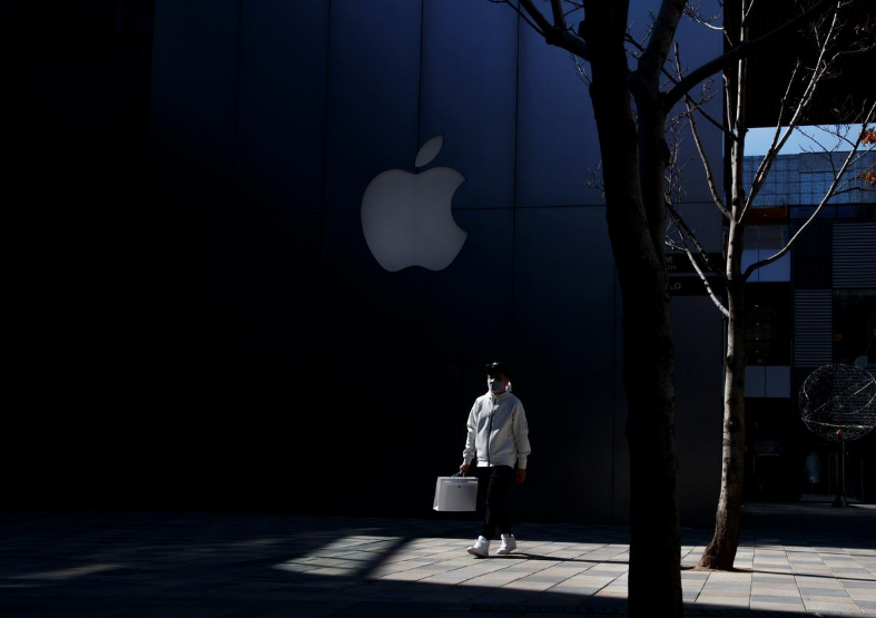 Человек в маске проходит мимо магазина Apple в престижном торговом районе Пекина. Китай, 4 марта 2020 года