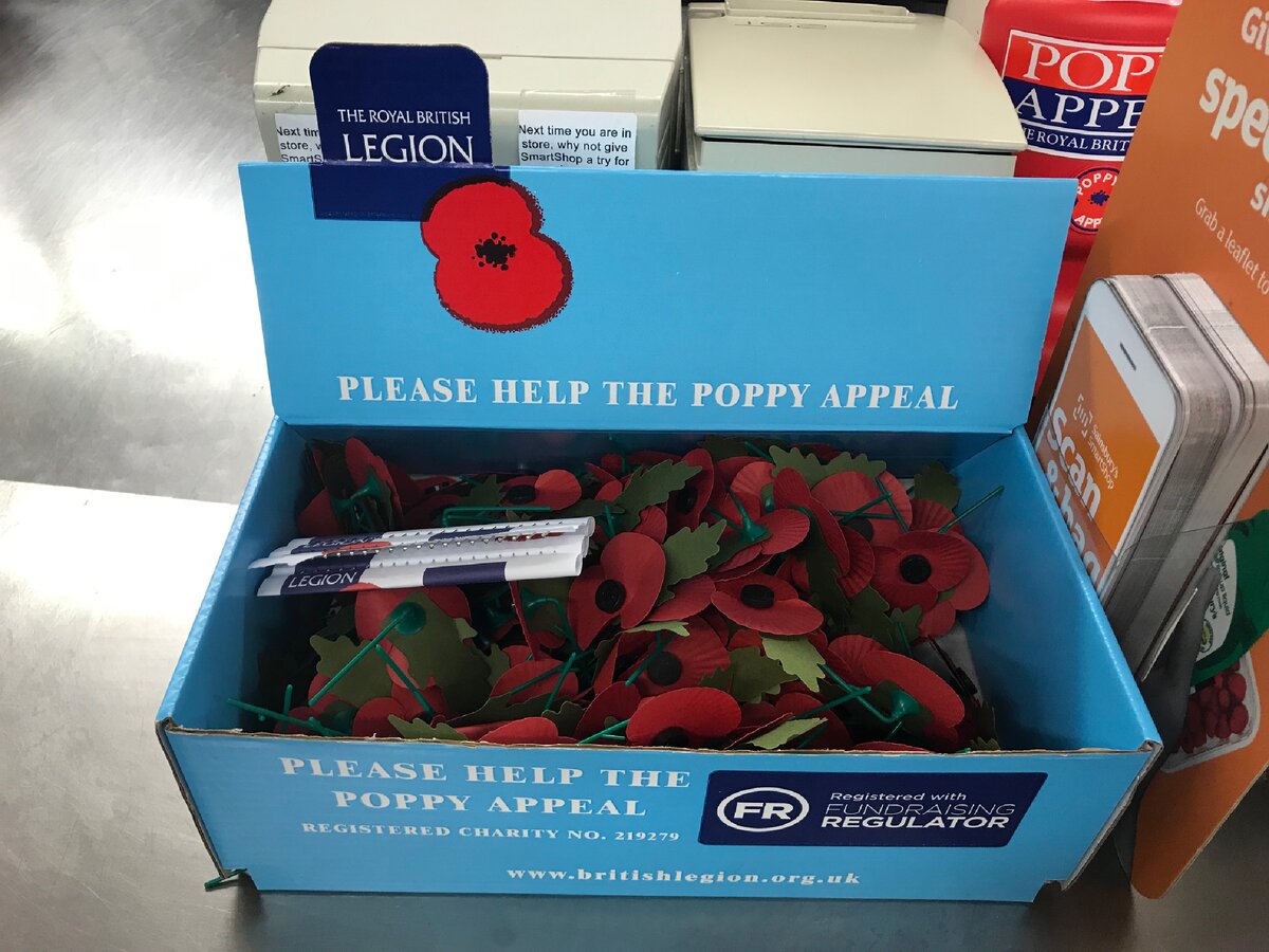 Такие коробки с бумажными маками на булавках стоят во многих общественных местах. Мак можно взять за пожертвование и приколоть цветок к лацкану. Фотография из личного архива.