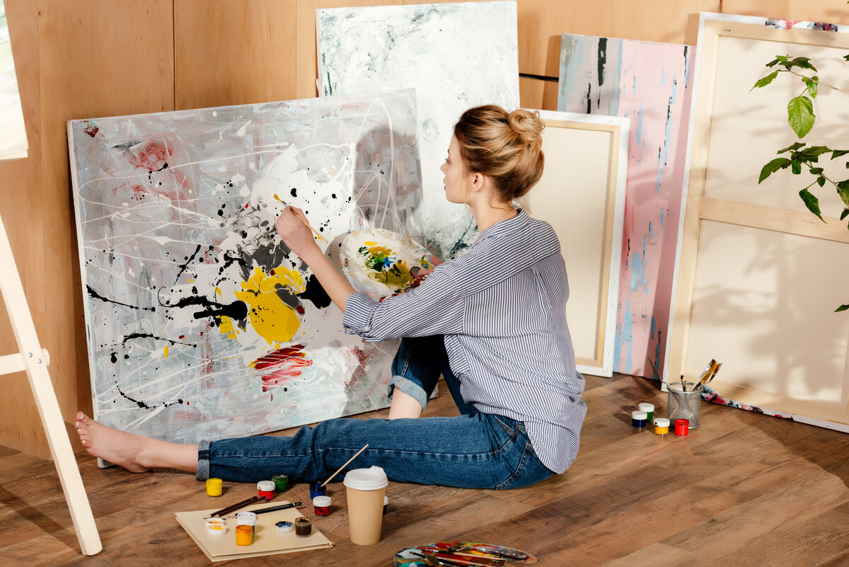 Look we are painting. Художница сидит на полу. Художник рисует на полу. Художница рисует на полу. Девушка рисует на полу.