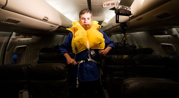 Спасательный жилет в самолете. Жилет в самолете. Самолетный спасательный жилет. Спасательные жилеты на борту самолёта. Спасательный жилет для пассажиров в самолете.