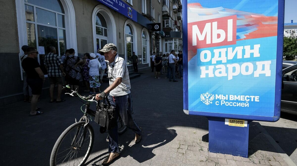    Жители Бердянска стоят в очереди у входа в пункт приема документов на гражданство Российской Федерации© РИА Новости / Константин Михальчевский