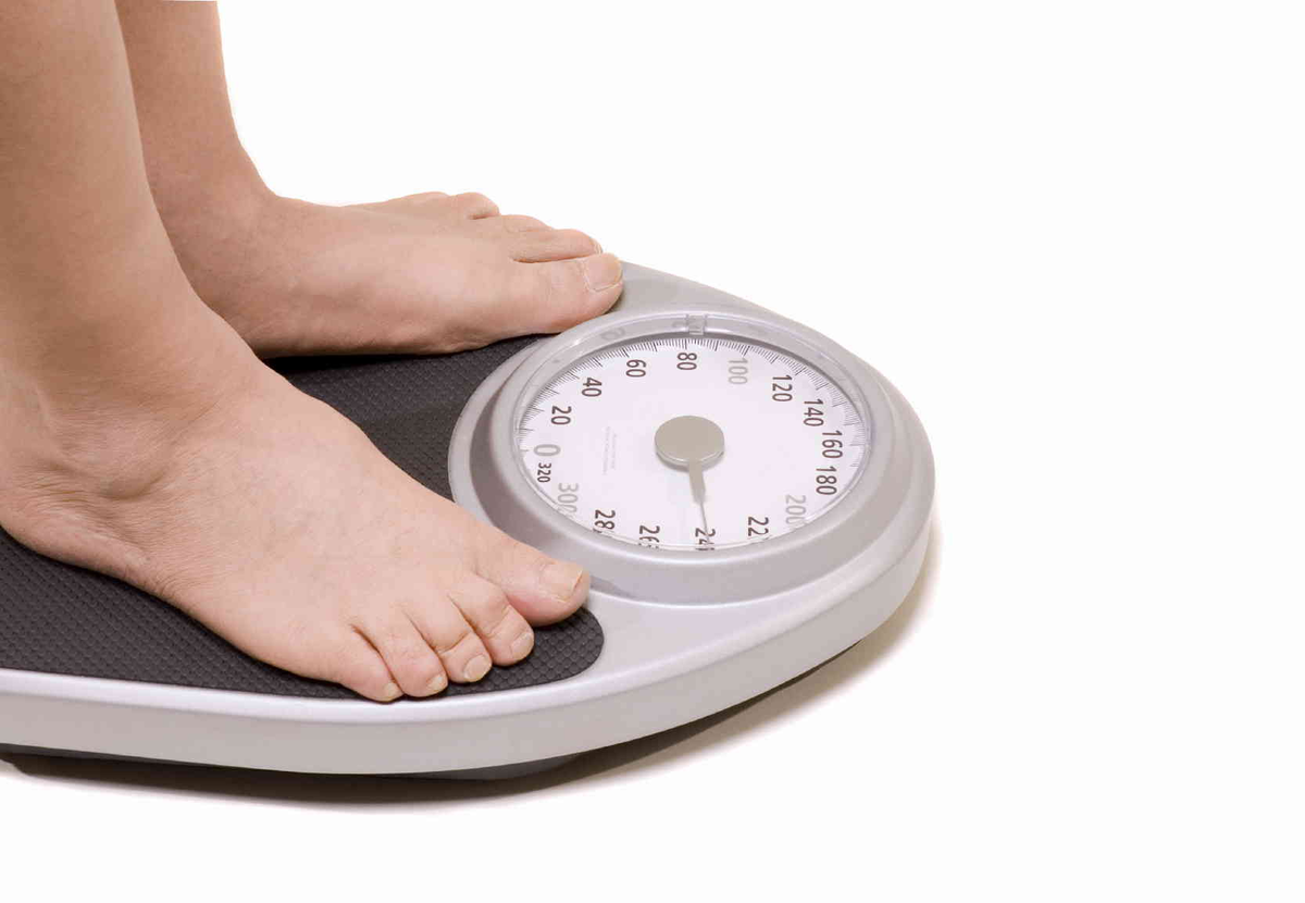 Бесплатного лишний вес. Взвешивание на весах. Контроль веса. Снижение массы тела. Ноги на весах.