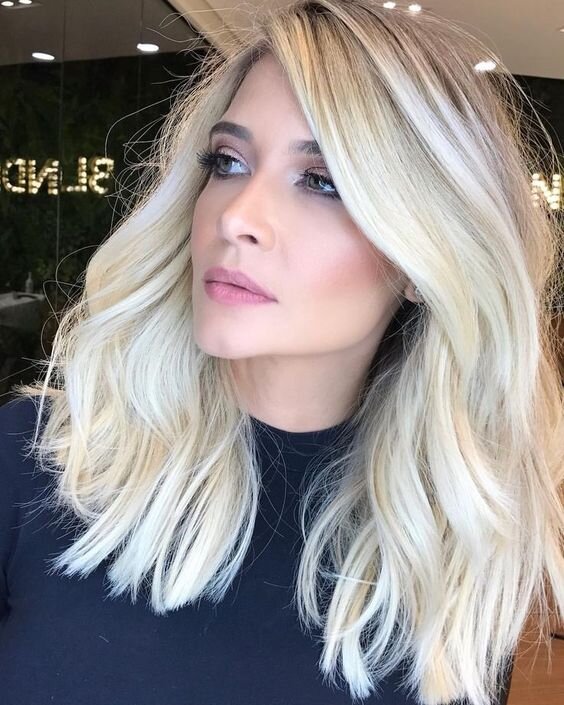 У девушки острый подбородок, но цвет волос и прическа не подчеркивают его. Девушка - красавица, наиболее модная на сегодня укладка волос средней длины, чуть завитые вертикальные локоны, как будто завиток почти сошёл после накручивания.