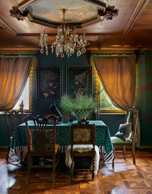 Столовая. Стулья разных эпох куплены на антикварных рынках в Италии, хрустальная люстра — в Словении. На стене висят картины из серии “Попутчики” авторства Николая Машукова. Резной потолок выполнил Виктор Логвинов. Пол сделан из африканского дерева ироко.