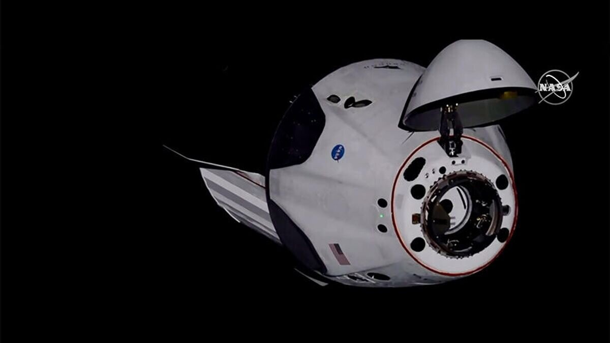    Американский корабль Crew Dragon компании SpaceX с астронавтами НАСА на борту во время стыковки с Межународной космической станцией. Стоп-кадр трансляции