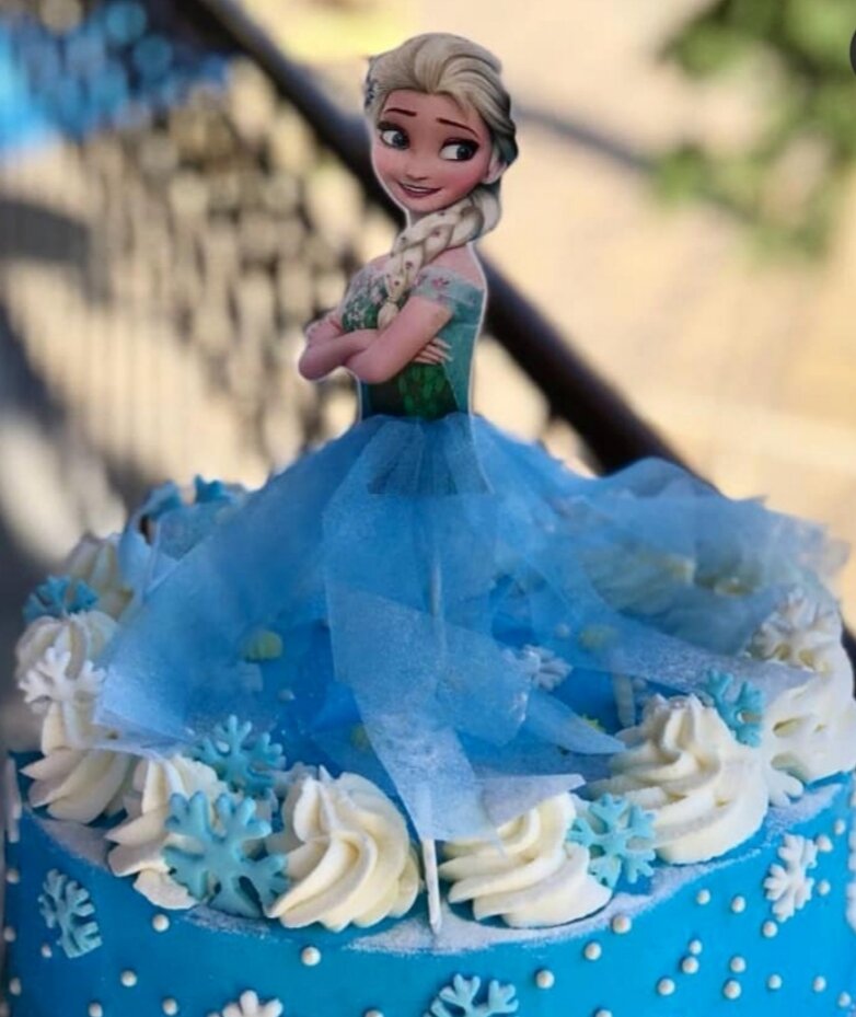 На фото торт украшен картинкой на картонной бумаге. Их в магазинах бесчисленное множество.