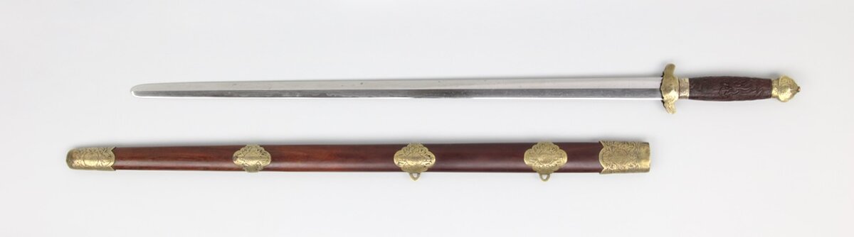 Можно сказать, канонический цзянь. Выглядит как галимый новодел и отчасти это правда... но лишь отчасти. Дело в том, что рукоять, гарда и ножны были изготовлены не так давно, а вот клинок XVII века. Далее - ттх.