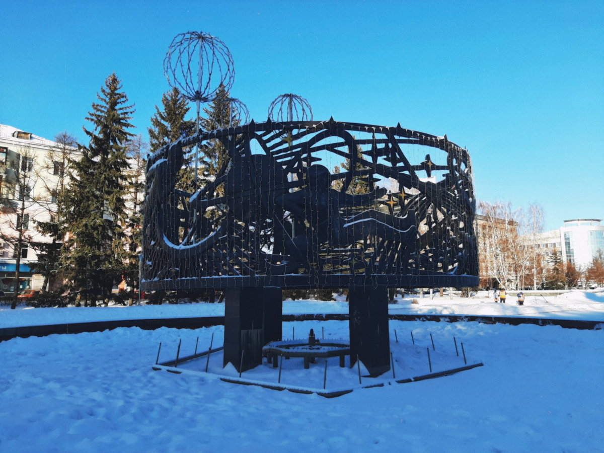 Это фонтан с космонавтами, но сейчас-то зима. Поэтому,  просто космическая инсталляция, увешанная гирляндой :)