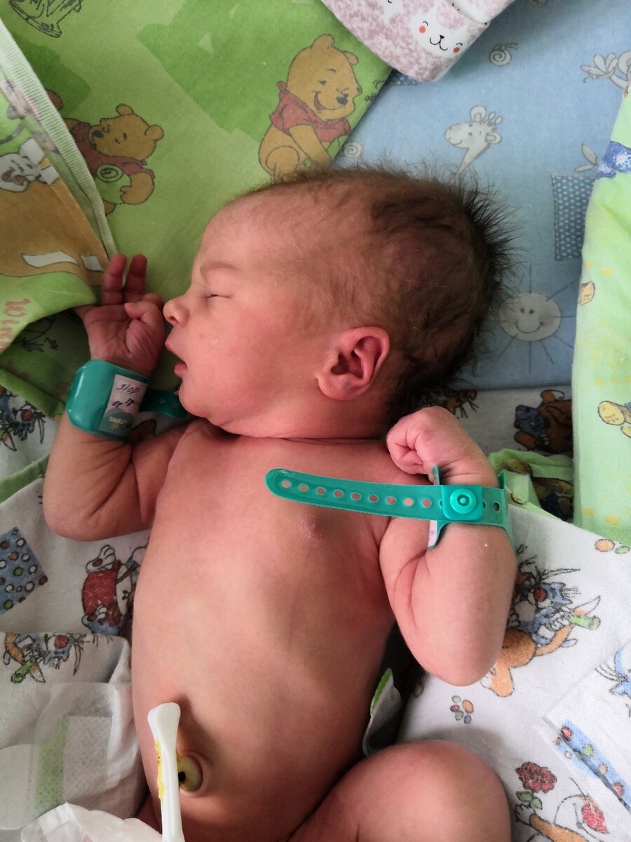 новорожденный с бирками на ручках