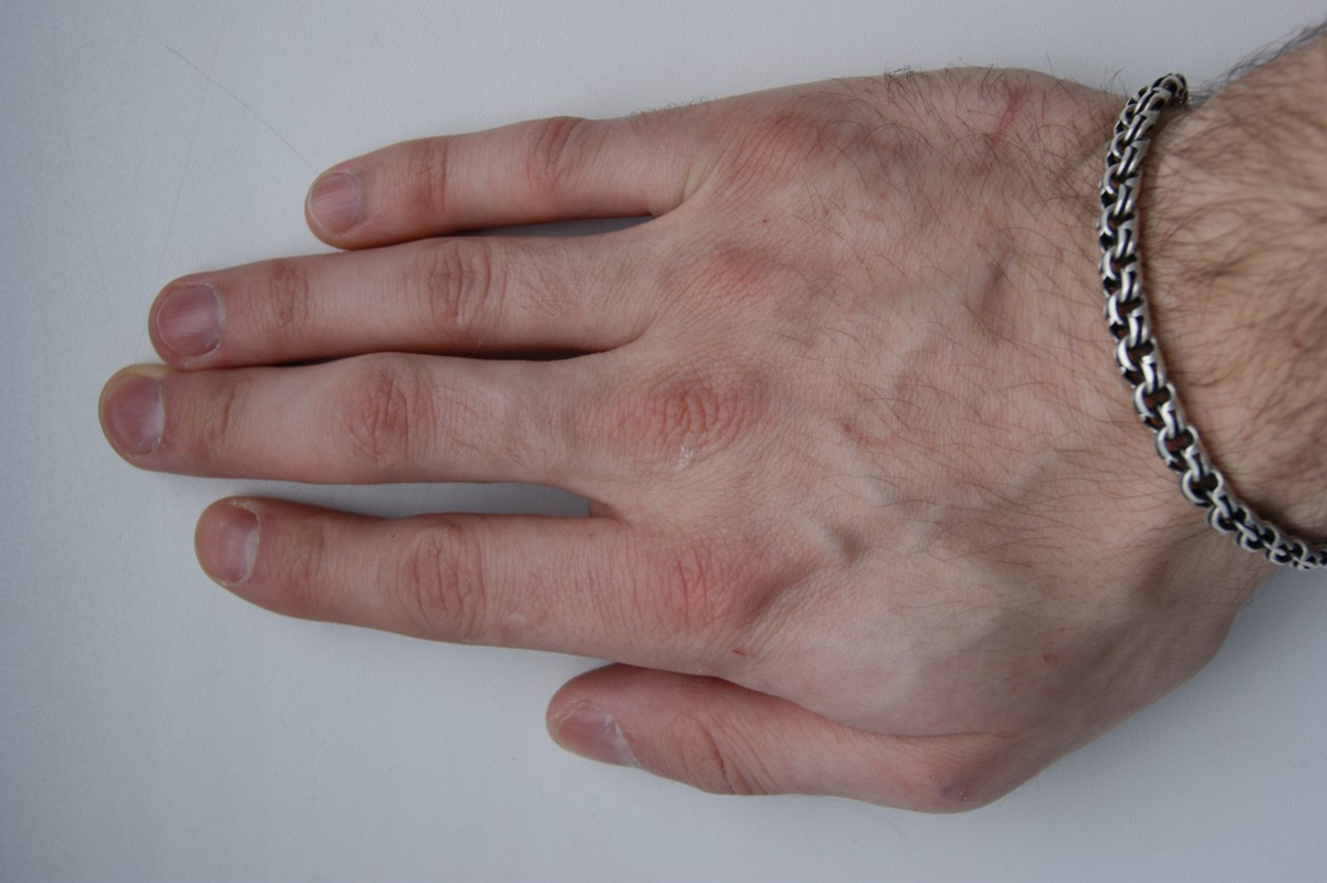 На фото большой палец плотно прижат к ребру ладони. 
