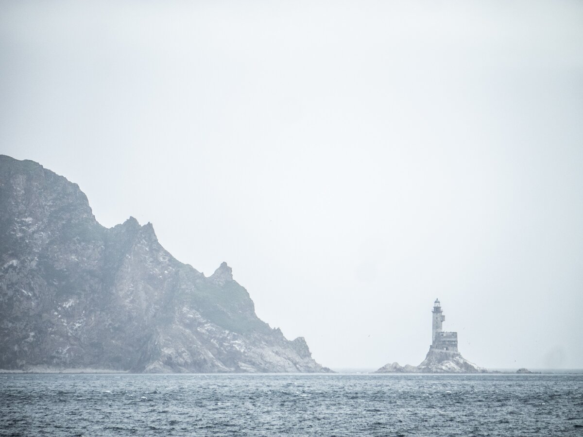 Вдалеке - заброшенный маяк Анива - это самый кончик восточного из двух "усов" южного Сахалина. Мимо него пролегает путь парома «Игорь Фархутдинов».