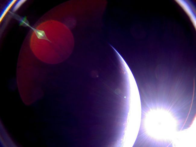 Бортовая камера аппарата LightSail сделала этот снимок освещённого Солнцем края диска Земли 6 июля 2019 года. Видны блики в объективе. The Planetary Society