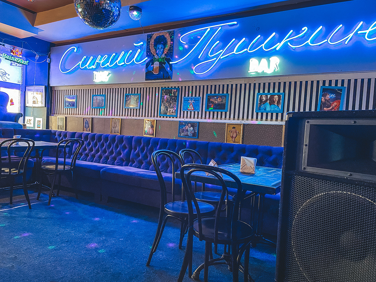 Неоновая вывеска и посадочные места с диванами →