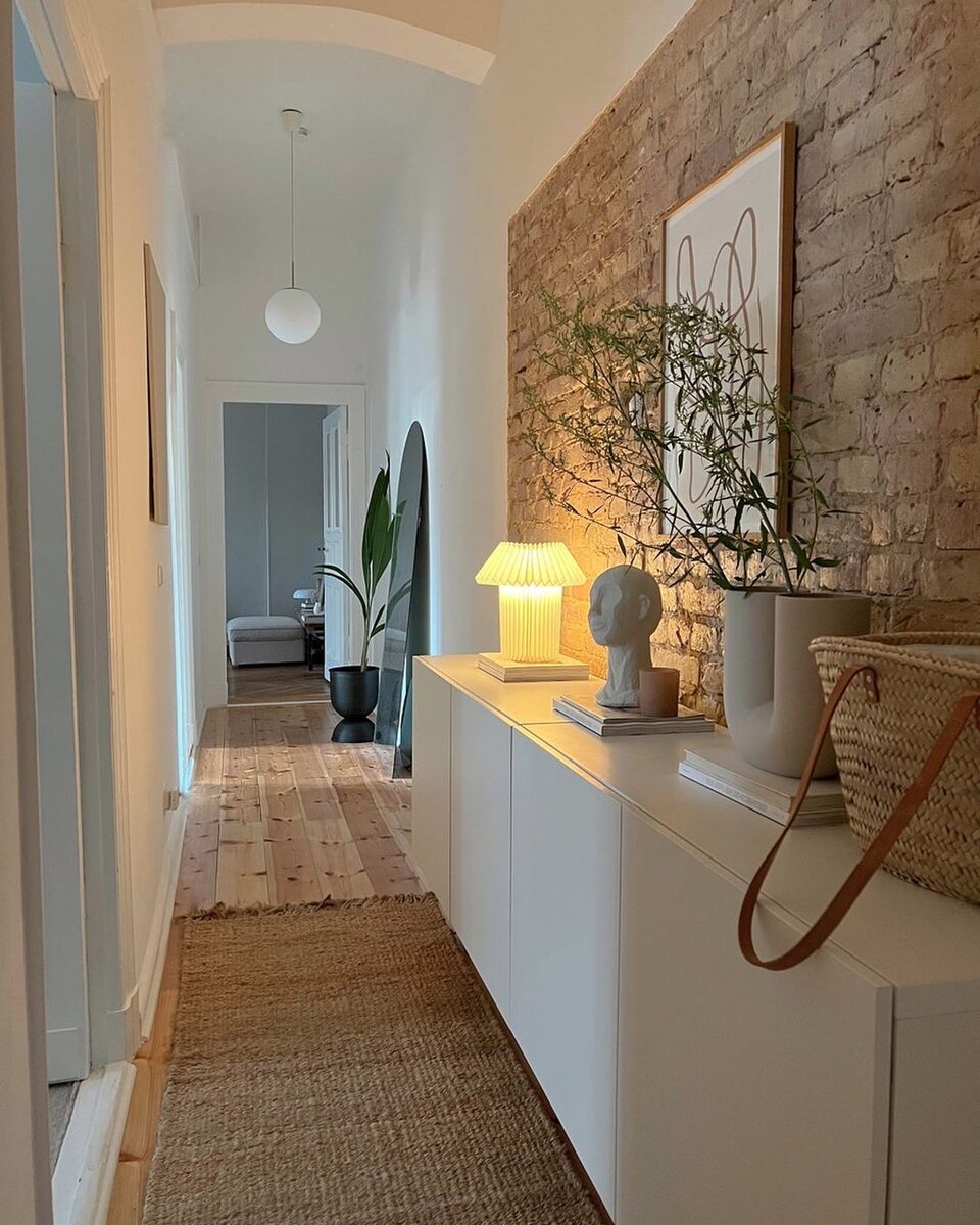 Начинаем с небольшой прихожей. Здесь весь акцент на стену из необработанного кирпича в стиле лофт