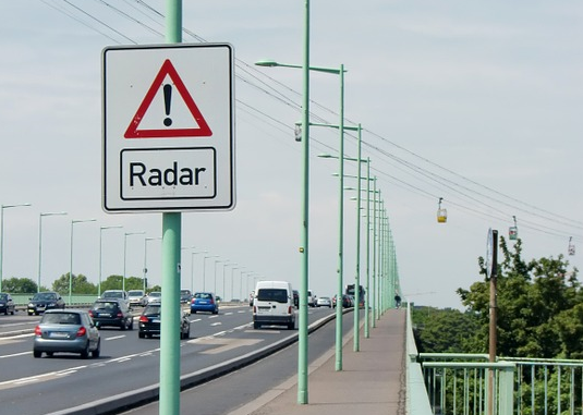 Предупреждающий о фиксации знак выглядит в зависимости от страны примерно так...