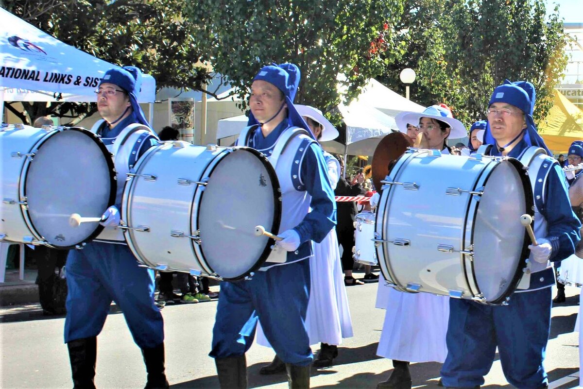 Генри (второй слева) играет на большом барабане в духовом оркестре Тянь Го после того, как Фалунь Дафа помог ему вернуть здоровье