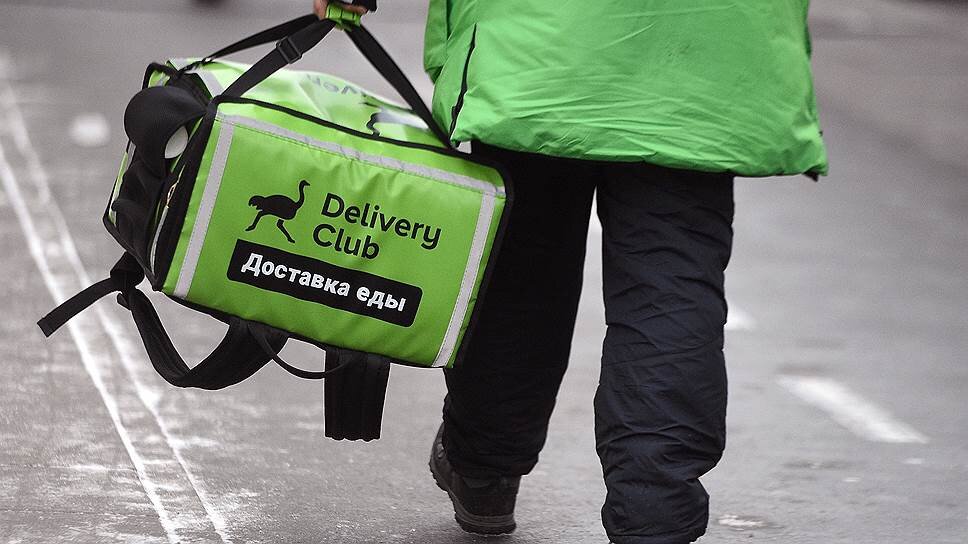 Сотрудник сервиса доставки еды выполняет заказ.